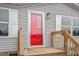 Close-up of the home's red front door, framed by white trim and a small porch at 7289 Nc 561, Louisburg, NC 27549