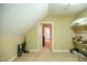Attic space with neutral carpet, access to other rooms, and built-in shelving at 7371 Leasburg Rd, Roxboro, NC 27574