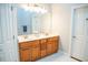 Bathroom featuring double sinks, a large mirror, and wooden cabinets at 7371 Leasburg Rd, Roxboro, NC 27574