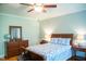 Cozy bedroom with wood dresser, globe, hardwood floors, ceiling fan, and bed at 7371 Leasburg Rd, Roxboro, NC 27574