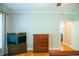 Relaxing bedroom with TV, hardwood floors, dresser, and open door at 7371 Leasburg Rd, Roxboro, NC 27574