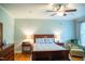 A serene bedroom features a wooden bed frame, ceiling fan, and side tables at 7371 Leasburg Rd, Roxboro, NC 27574