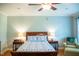 A serene bedroom features a wooden bed frame, ceiling fan, and side tables at 7371 Leasburg Rd, Roxboro, NC 27574