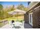Outdoor deck showcasing a dining set and a grill, overlooking a spacious backyard at 7371 Leasburg Rd, Roxboro, NC 27574