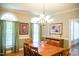 Elegant dining room with hardwood floors, chandelier lighting, and ample natural light from large windows at 7371 Leasburg Rd, Roxboro, NC 27574