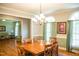 Charming dining room featuring hardwood floors, a chandelier, and natural light from arched windows at 7371 Leasburg Rd, Roxboro, NC 27574