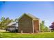 Side exterior featuring a two-car garage and brick facade at 7371 Leasburg Rd, Roxboro, NC 27574
