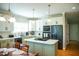 Modern kitchen featuring white cabinets, stainless steel appliances, and a center island cooktop at 7371 Leasburg Rd, Roxboro, NC 27574