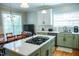 Bright kitchen with green cabinetry, stainless appliances, and a spacious island at 7371 Leasburg Rd, Roxboro, NC 27574