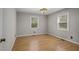 Cozy bedroom with neutral walls, wood floors, and two bright windows at 952 Glover Rd, Dunn, NC 28334