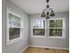 Bright dining room featuring three windows and a decorative hanging light fixture at 952 Glover Rd, Dunn, NC 28334