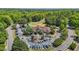 Aerial view of the clubhouse and parking lot, surrounded by golf course and beautiful trees at 5113 Windance Pl, Holly Springs, NC 27540