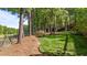A well manicured backyard with mature trees and plants bordering a neighborhood golf course at 5113 Windance Pl, Holly Springs, NC 27540