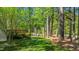 Serene backyard with a deck nestled among mature trees offering privacy and natural beauty at 5113 Windance Pl, Holly Springs, NC 27540