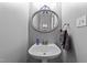 Compact bathroom featuring a modern sink, oval mirror, and fresh towels at 5113 Windance Pl, Holly Springs, NC 27540