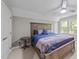 Comfortable bedroom featuring a wooden bed frame, soft blue linens, and a bright window at 5113 Windance Pl, Holly Springs, NC 27540