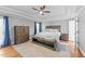 Bright bedroom featuring tray ceilings, ceiling fan and wood furnishings on top of a diamond patterned rug at 5113 Windance Pl, Holly Springs, NC 27540
