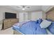Cozy bedroom with large television, dresser, walk-in closet, and comfortable blue bedding at 5113 Windance Pl, Holly Springs, NC 27540
