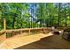 A spacious wood deck with wood railing and a view of lush green trees surrounding the property at 5113 Windance Pl, Holly Springs, NC 27540
