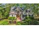 Charming stone front home with mature landscaping, manicured lawn, and arched window at 5113 Windance Pl, Holly Springs, NC 27540