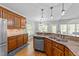 Bright kitchen featuring granite countertops, stainless steel dishwasher, and wood cabinets at 5113 Windance Pl, Holly Springs, NC 27540