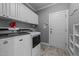 Well-organized laundry room with white cabinets, washer, and dryer at 5113 Windance Pl, Holly Springs, NC 27540