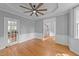 Spacious living room with hardwood floors, ceiling fan, and white trim at 5113 Windance Pl, Holly Springs, NC 27540