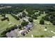Aerial view of a golf course and clubhouse featuring lush greens, mature trees, and a scenic layout at 10 Twinleaf Pl, Durham, NC 27705