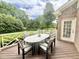 Outdoor deck featuring a table for six, looking out onto a lush green backyard at 10 Twinleaf Pl, Durham, NC 27705
