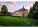 Large backyard with a well-manicured lawn, mature trees, and rear exterior view of home at 10 Twinleaf Pl, Durham, NC 27705