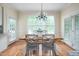 Bright dining area featuring a wooden table with seating for four, next to large windows and door at 10 Twinleaf Pl, Durham, NC 27705