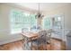 Sunlit breakfast area with a rustic table, modern lighting, and view of backyard at 10 Twinleaf Pl, Durham, NC 27705