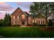 Elegant brick home boasting a manicured lawn, mature trees, and classic black shutters at 10 Twinleaf Pl, Durham, NC 27705