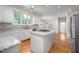 Bright kitchen featuring a center island with granite countertops, white cabinets and stainless appliances at 10 Twinleaf Pl, Durham, NC 27705