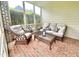 Relaxing screened porch with comfortable wicker furniture and a glass coffee table at 10 Twinleaf Pl, Durham, NC 27705