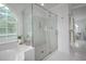 Modern glass walk-in shower with tile surround and arched window, offering a spa-like experience at 10 Twinleaf Pl, Durham, NC 27705