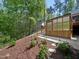 Backyard with flower beds, steps leading up to the back deck, and a storage area at 104 Blue Finch Ct, Youngsville, NC 27596