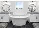 Bright bathroom featuring a soaking tub, granite counters, and stylish lighting at 104 Blue Finch Ct, Youngsville, NC 27596