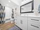 Elegant bathroom with white cabinets, double vanity, and a framed mirror at 104 Blue Finch Ct, Youngsville, NC 27596