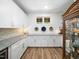 Stylish butler's pantry boasting white cabinets, granite countertops, and a built-in wine cooler at 104 Blue Finch Ct, Youngsville, NC 27596
