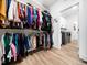 Walk-in closet filled with colorful clothing, shelves, and hardwood floors at 104 Blue Finch Ct, Youngsville, NC 27596