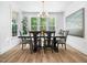 Bright dining room features large windows, wood floors, stylish chandelier, and backyard views at 104 Blue Finch Ct, Youngsville, NC 27596