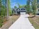 Long driveway leading to a beautiful home nestled amongst mature trees on a sunny day at 104 Blue Finch Ct, Youngsville, NC 27596