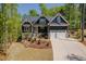 Charming exterior showcasing meticulous landscaping, stone accents, and a two-car garage at 104 Blue Finch Ct, Youngsville, NC 27596