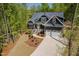 Stunning home exterior with lush greenery, a stone foundation, and an extended driveway at 104 Blue Finch Ct, Youngsville, NC 27596
