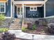 Inviting front porch with comfortable seating, stone details, and a well-maintained landscape at 104 Blue Finch Ct, Youngsville, NC 27596