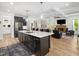 A kitchen island with sink opens to the living room with fireplace and exposed beam ceiling at 104 Blue Finch Ct, Youngsville, NC 27596