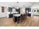 Bright eat-in kitchen features a center island with sink, black cabinets, and stainless steel appliances at 104 Blue Finch Ct, Youngsville, NC 27596