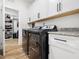 Modern laundry room features stainless steel washer and dryer with ample cabinet space at 104 Blue Finch Ct, Youngsville, NC 27596