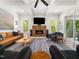 Elegant living room with fireplace, comfortable seating, lots of natural light, and wood floors at 104 Blue Finch Ct, Youngsville, NC 27596
